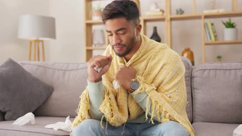 Young Adult Coughing on Couch at Home