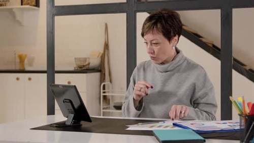 Woman Talking and Writing at Desk