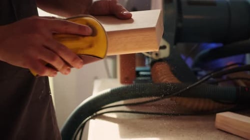 Woodworking Specialist Using Sandpaper to Do Manual Sanding on Lumber Close Up