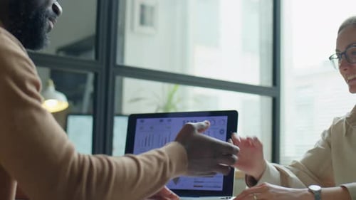 Coworkers Talking and Shaking Hands in Office