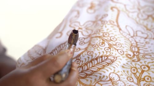La técnica de hacer batik dibujado a mano con una herramienta de inclinación. Este artesano está haciendo batik typica
