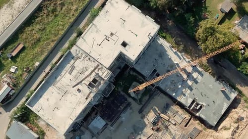 Blick von oben auf den Turmdrehkran und die Betondachplatten auf der Baustelle, sichtbar im frühen Stadium von