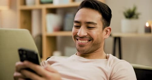 Man Smiling and Looking at a Smartphone