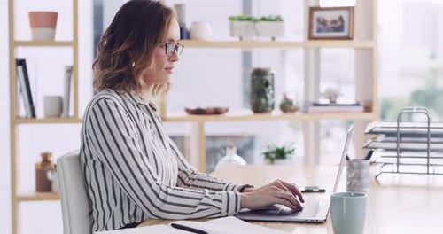 4k video footage of an attractive young businesswoman working on a laptop in a modern office