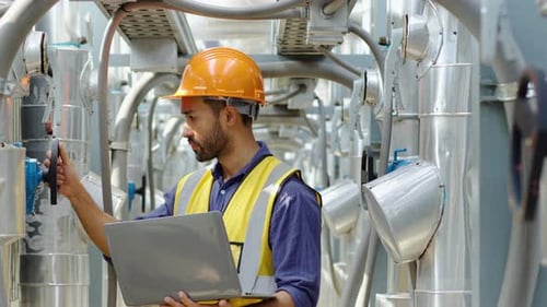 Young male technical foreman inspection maintenance work holding a laptop to look at plumbing