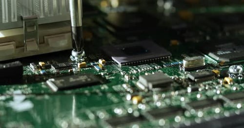 Close-up of tightening a screw on a computer motherboard.