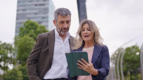 Business Professionals Reviewing Tablet in City Environment