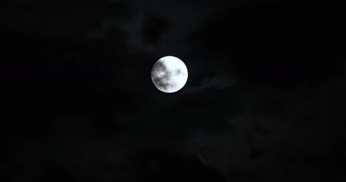 Bright Full Moon Glows in Dark Cloudy Night Sky
