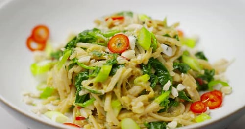 Asian noodles with coriander chilli and scallions. Plant-based child noodle bowl shot in 4k with sha