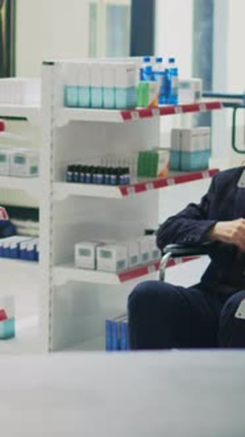 Senior Man in Wheelchair Assisted in Pharmacy