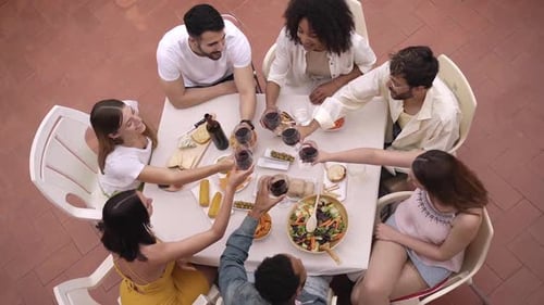 Top View of Happy Group of Friends Toasting with Red Wine Outside in a Terrace Celebrating
