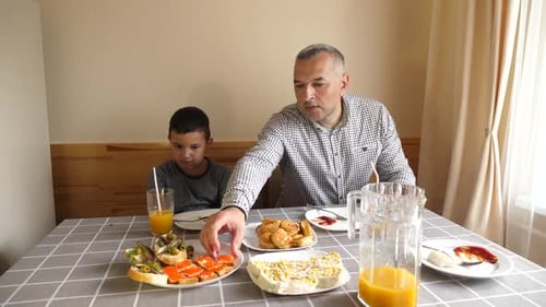 Father and Son Sharing a Meal at Home