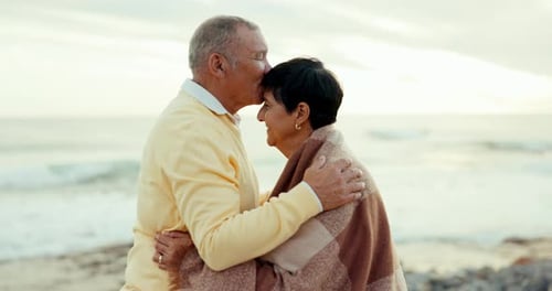 Senior couple, love and kiss at beach for care, commitment and adventure outdoor