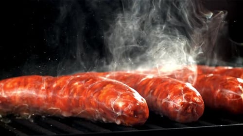 Smoking Sausages Cooking on a Grill Close Up