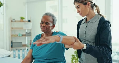 Therapist Assists Senior Woman with Arm Exercises