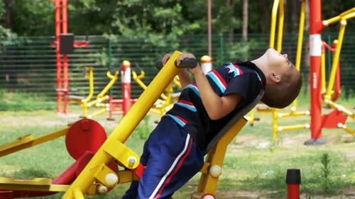 Child Boy Engaged on Sports Training Simulator at the Street in Slow Motion