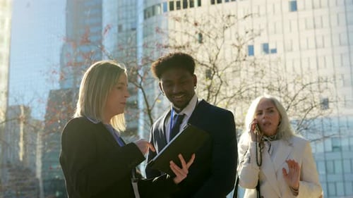 Business Team Discussing Tablet in Urban Setting