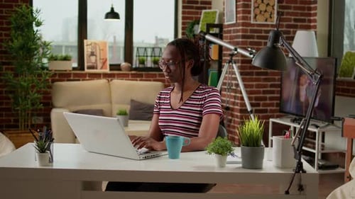 Woman Typing on Laptop and Working at Desk