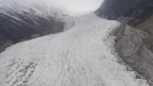Aerial View of a Majestic Glacier in the Mountains of Pakistan Enveloped in a Mystical Fog