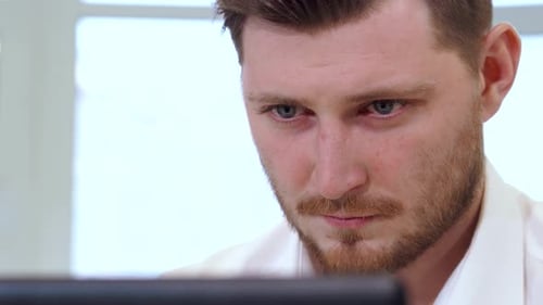 Konzentrierter männlicher Manager, der intensiv an seinem Laptop arbeitet