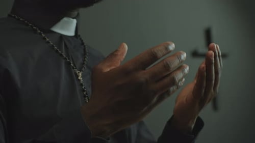Hands of Black Catholic Priest Speaking on Liturgical Service in Church