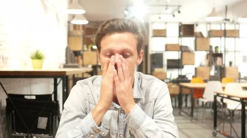 Young Man Having Headache in Office