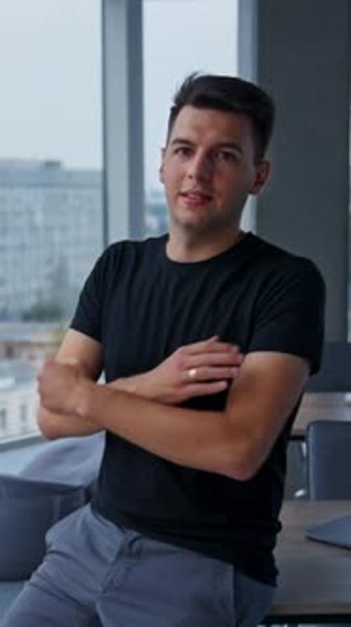 Confident Young Man Poses by Office Window