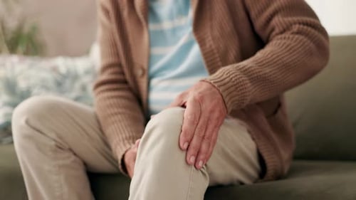 Senior, man and sofa with hands for knee pain or aging joints, inflammation