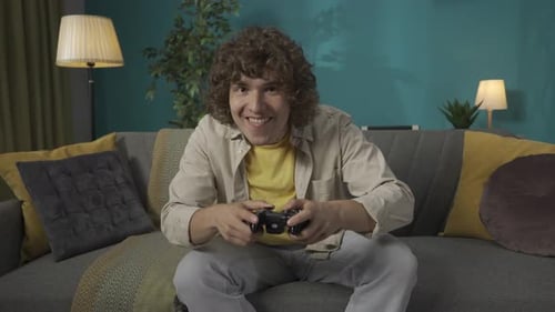 Excited Young Man Playing Video Game at Home
