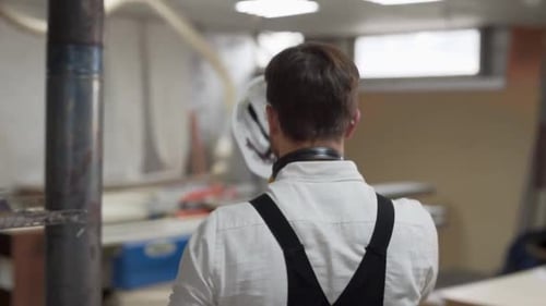 closeup rear view, worker goes and wears hard hat