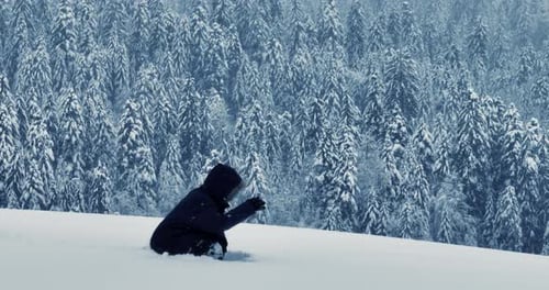 Wanderer, der im Tiefschnee draußen in der Waldlandschaft spaziert