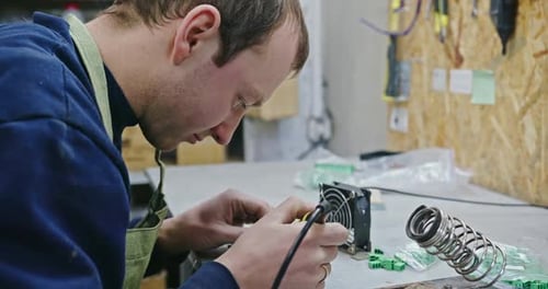 Man Soldering Wires in Workshop Close Up