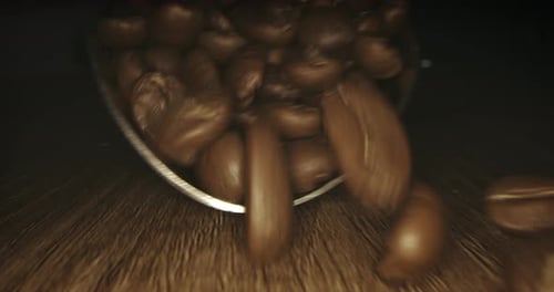 Roasted Coffee Beans Being Poured onto Wooden Surface