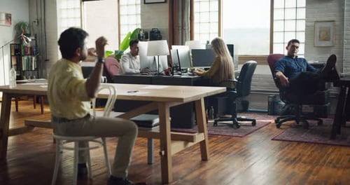 Employees Working On Computers And On Paper On A Desk In Modern Well Lit Office During The Day. W...
