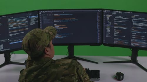 Back View Of Bored Asian Man Soldier Write Code With Multiple Screens In Green Screen