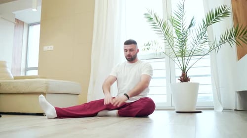 Man Stretching Legs on the Floor at Home