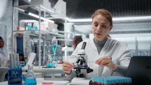 Molecular Biologist Using Compound Microscope for Detailed Cellular Analysis