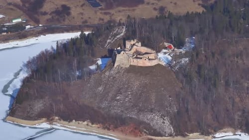Aerial view of an ancient castle in a snowy landscape during winter