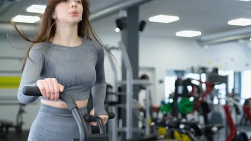 Cardio Workout of a Beautiful Longhaired Woman in the Gym on a Bicycle Exercise Bike