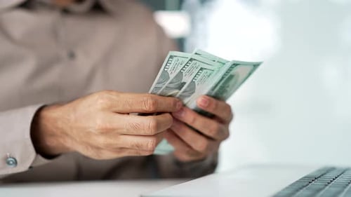 Close up. Male hands count one hundred dollar US bills. Happy businessman in a shirt counting
