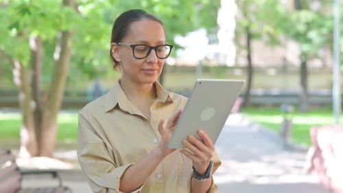 Multi Ethnic Woman Using a Tablet in a Park