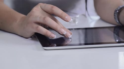 Mulher morena usa tablet para navegar na Internet no varejo na cozinha