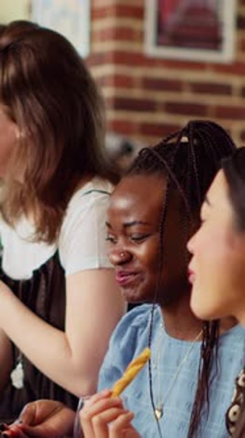 Three Women Enjoy Food and Drinks at Party