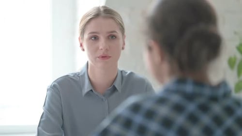 Junge blonde Frau spricht während des Treffens mit einer Inderin