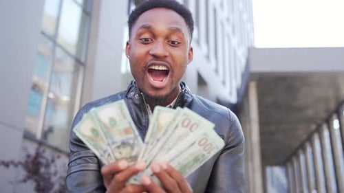 Man Excitedly Holding a Stack of Hundred Dollar Bills
