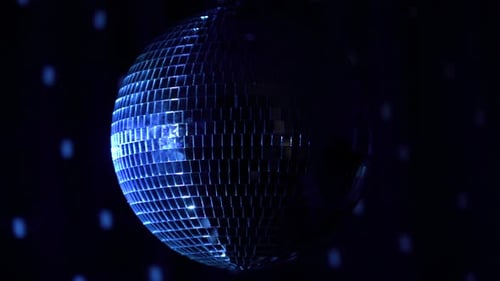 Shimmering disco ball reflects light in dark club setting
