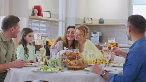 Family Celebrates at Dinner Table Inside Home