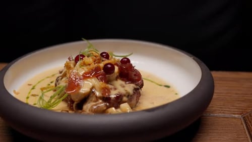 Gourmet Steak Medallion Topped with Crispy Bacon Forest Berries and Creamy Mushroom Sauce Elegantly