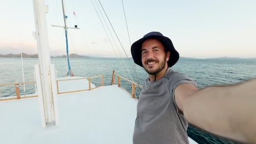 Man on Boat Waving With Tropical Island View