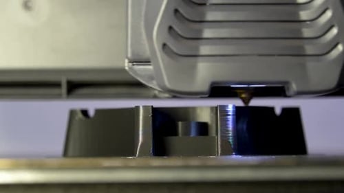 Drucken eines schwarzen Kunststoffstücks in Zeitlupe mit einem 3D-Drucker